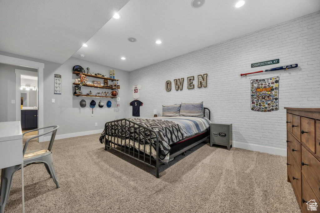 Bedroom featuring carpet floors, recessed lighting, and brick wall