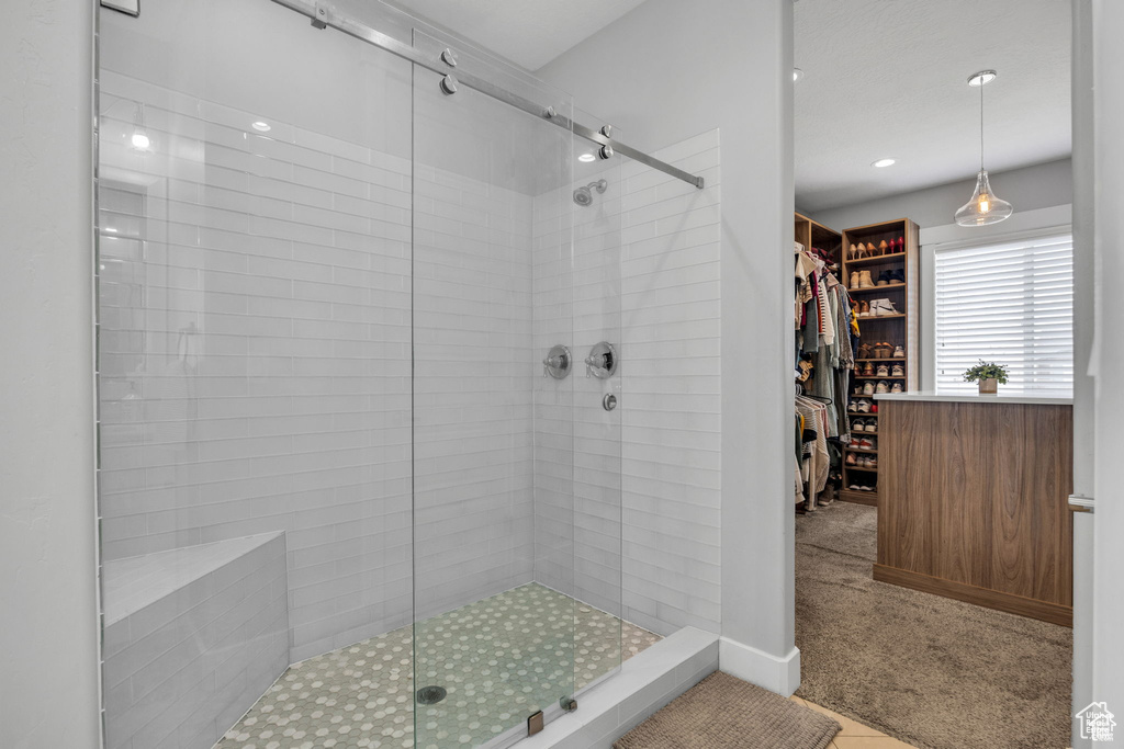Full bath featuring a shower stall and a walk in closet