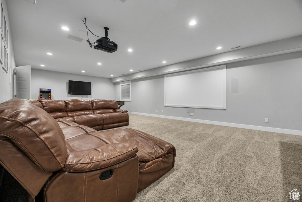 Carpeted cinema room with recessed lighting
