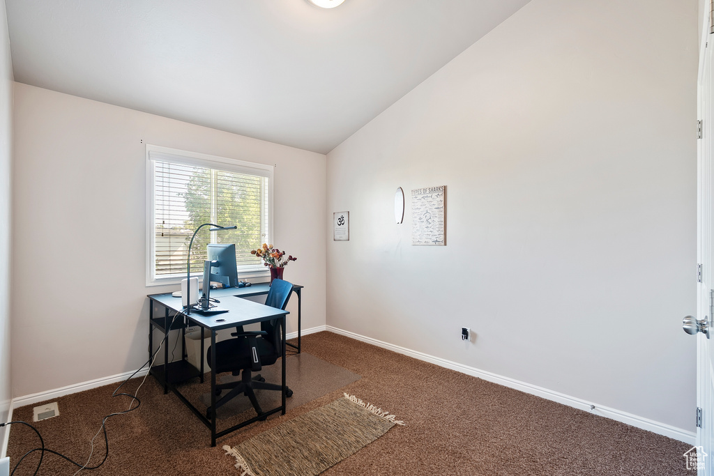 Carpeted home office featuring baseboards and lofted ceiling