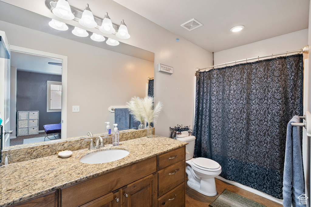 Ensuite bathroom with vanity, tile patterned floors, and a shower with curtain