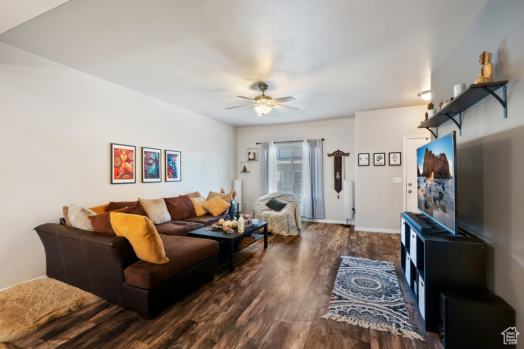 Living area with dark wood-type flooring and a ceiling fan