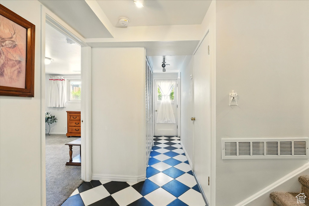 Hall featuring tile patterned floors, baseboards, and stairs