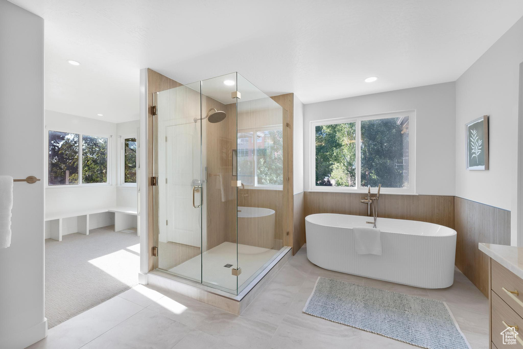 Full bathroom featuring a soaking tub, a wainscoted wall, a shower stall, and recessed lighting