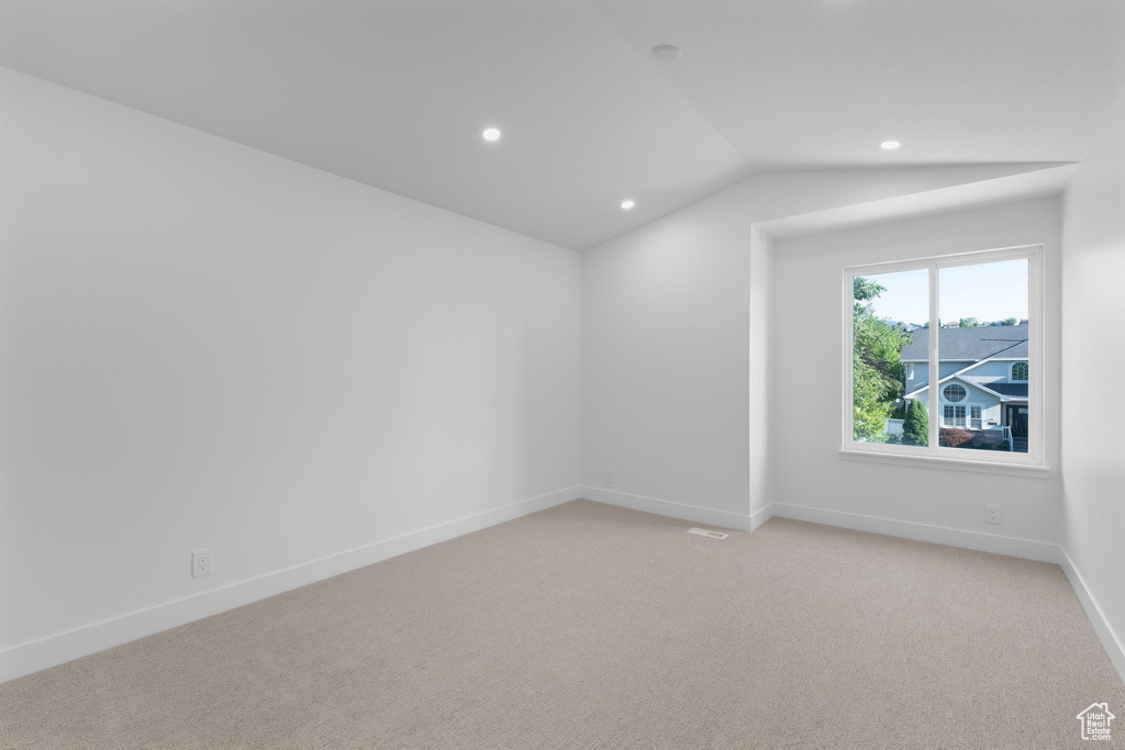Unfurnished room with recessed lighting, light carpet, vaulted ceiling, and baseboards