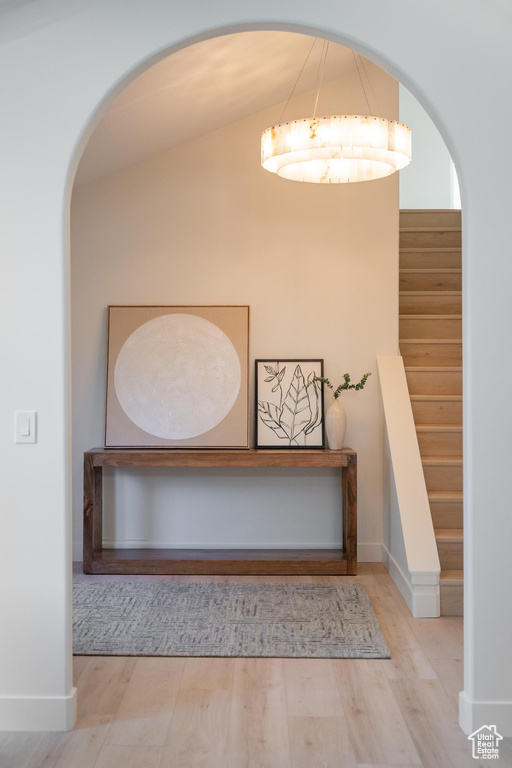 Staircase featuring wood finished floors, baseboards, and vaulted ceiling