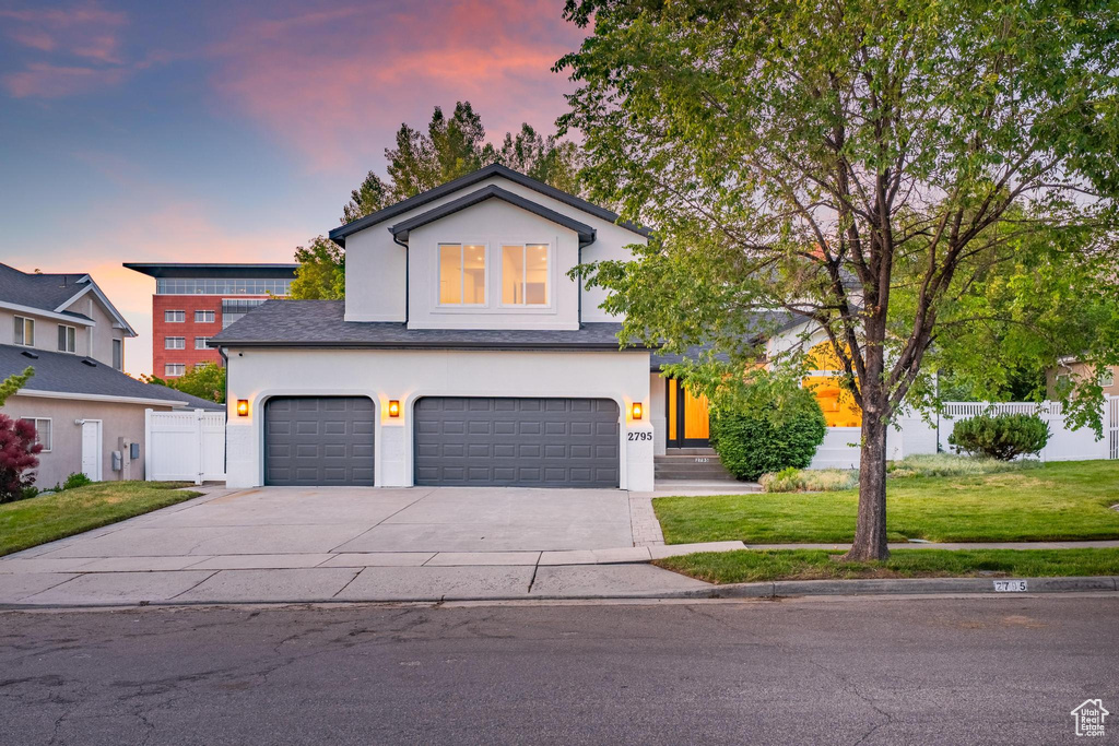View of front of home featuring concrete driveway, an attached garage, and stucco siding