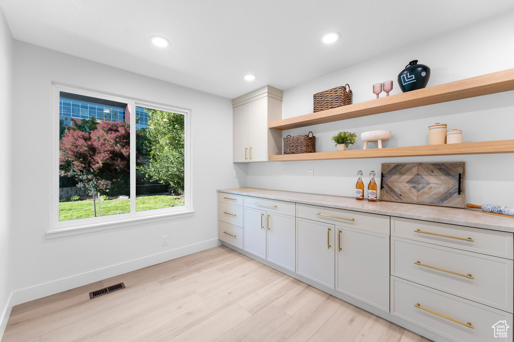 Bar area featuring light wood-style floors, recessed lighting, and baseboards