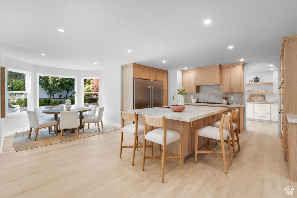 Dining space with light wood-style flooring, recessed lighting, and baseboards