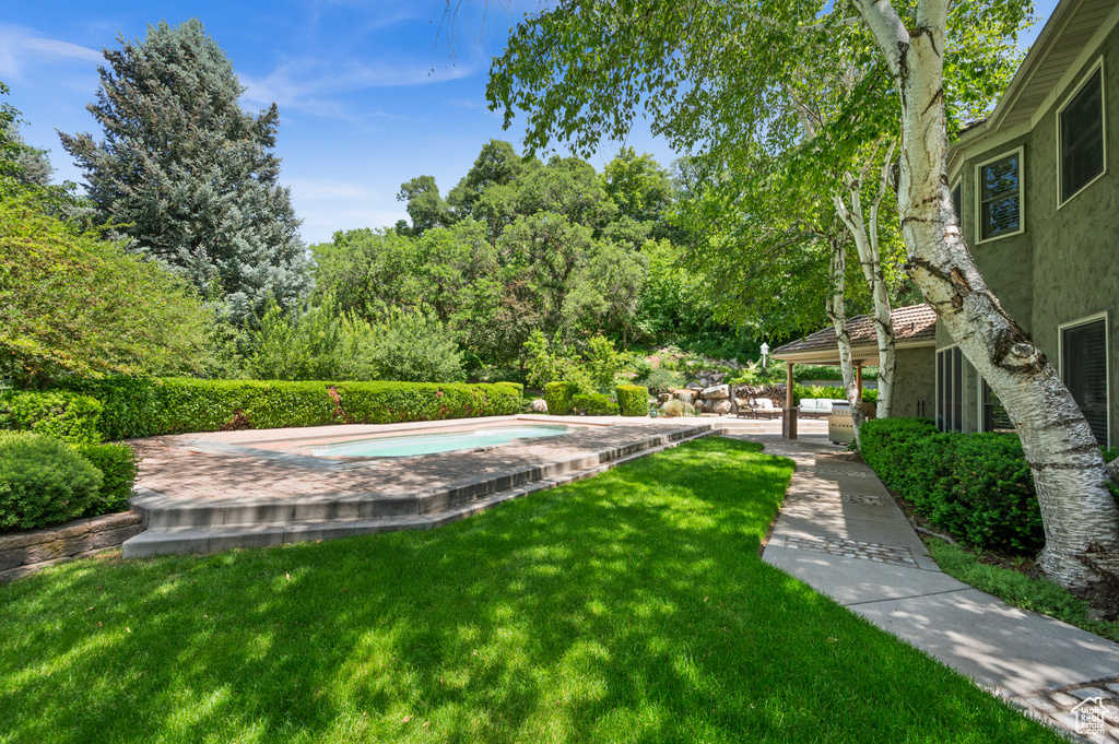 View of green lawn featuring a jacuzzi