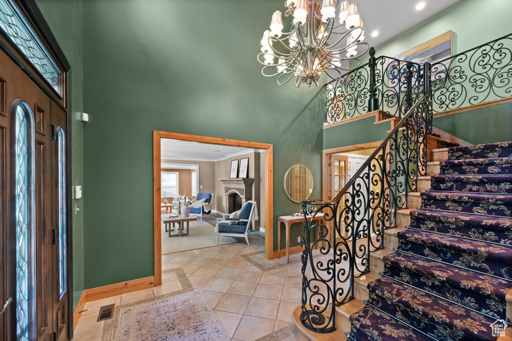 Foyer entrance with a towering ceiling, baseboards, stairs, recessed lighting, and a chandelier