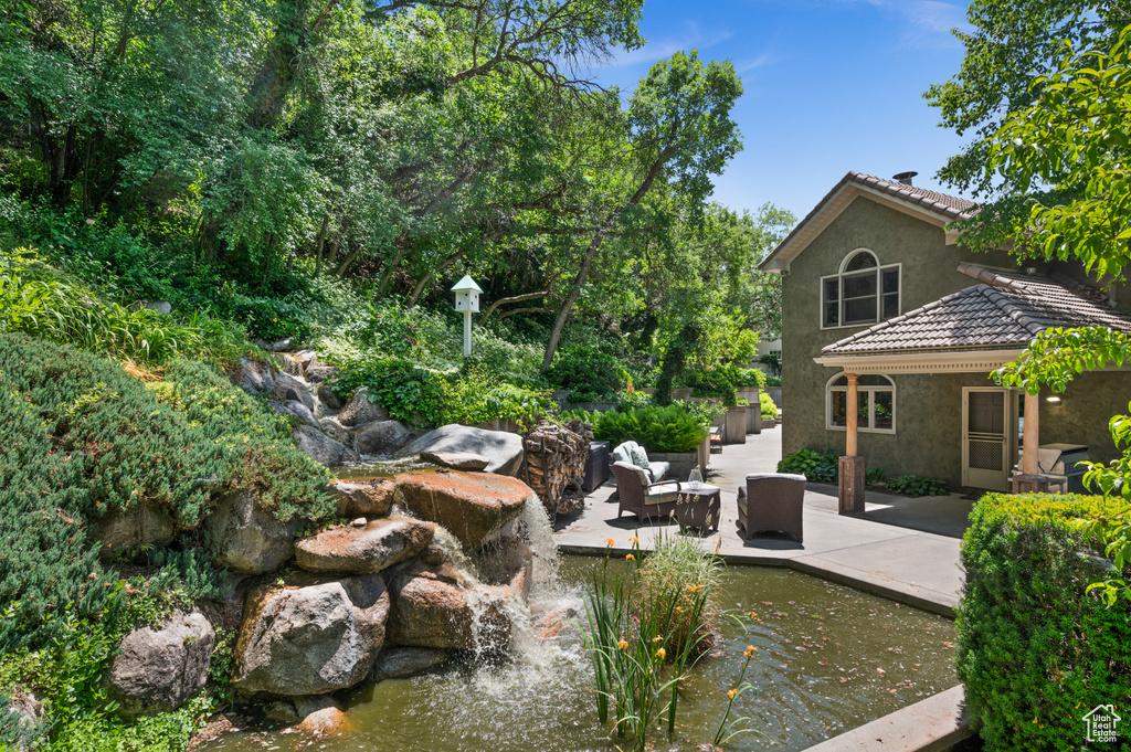 View of yard with a small pond and a patio
