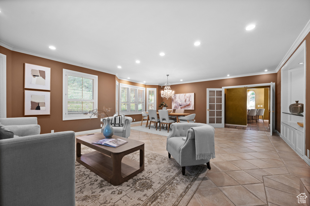 Living room with recessed lighting, a chandelier, baseboards, crown molding, and light tile patterned floors