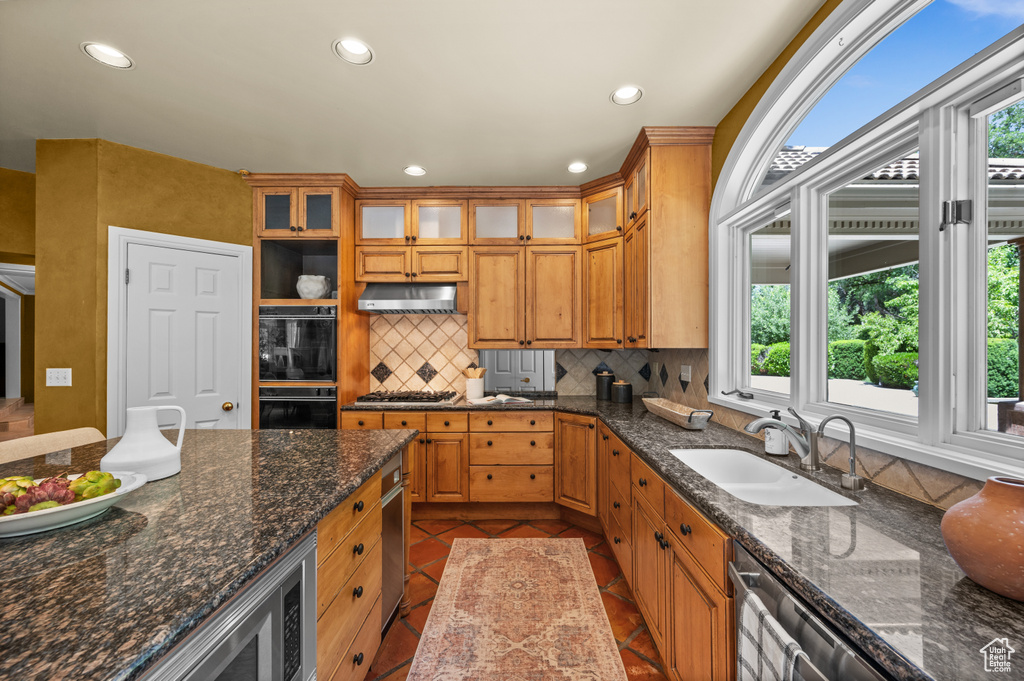 Kitchen with a sink, under cabinet range hood, tasteful backsplash, recessed lighting, and dishwasher