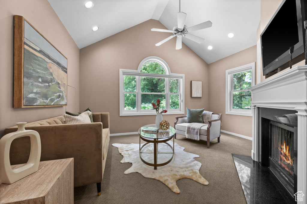Living room featuring vaulted ceiling, healthy amount of natural light, a fireplace, carpet floors, and baseboards