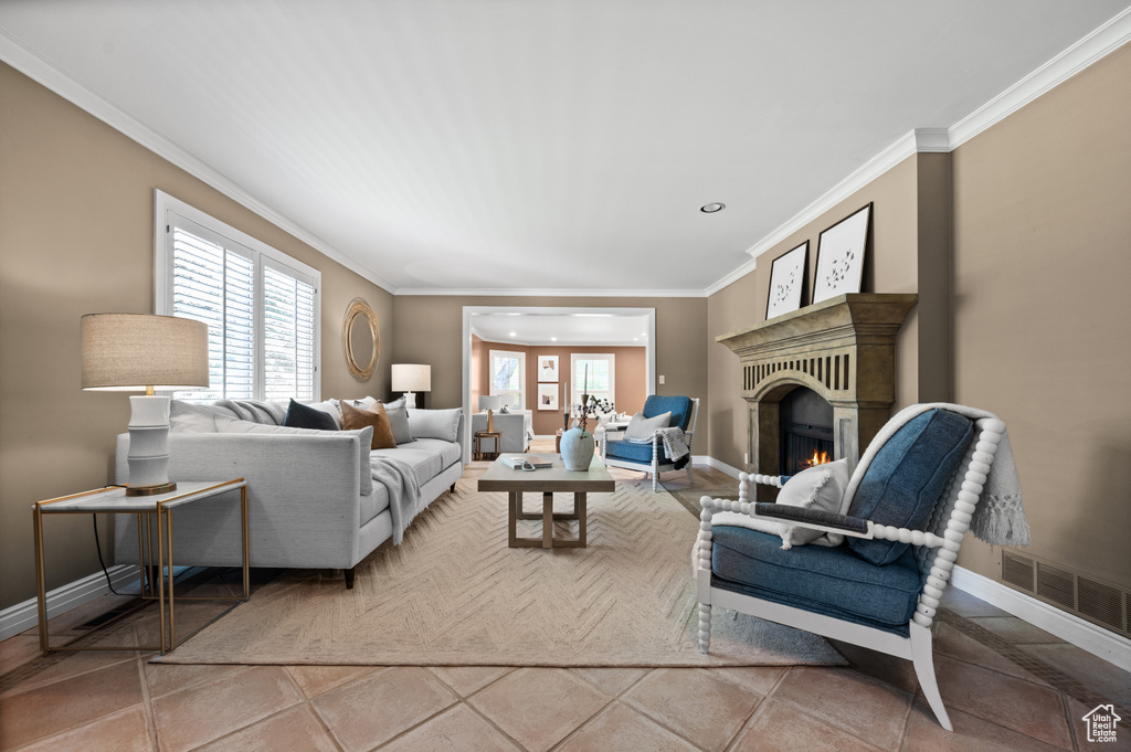 Living area featuring baseboards, ornamental molding, recessed lighting, and a lit fireplace
