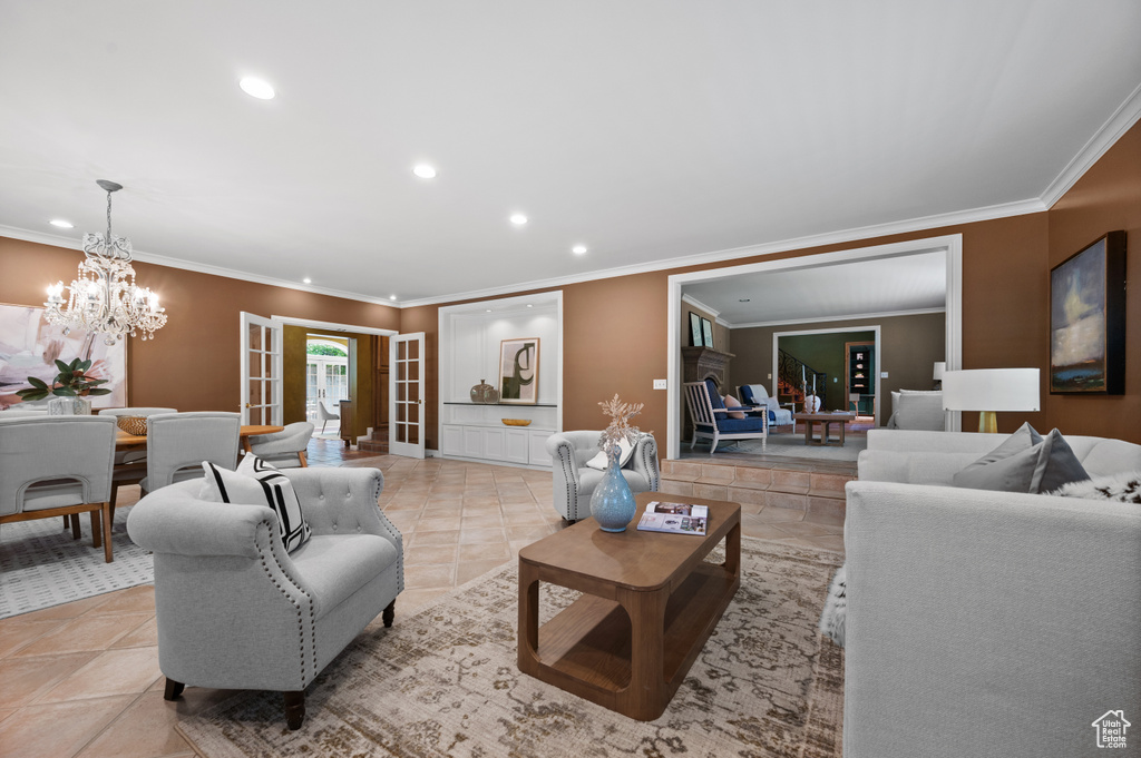 Living room with recessed lighting, ornamental molding, a chandelier, and baseboards
