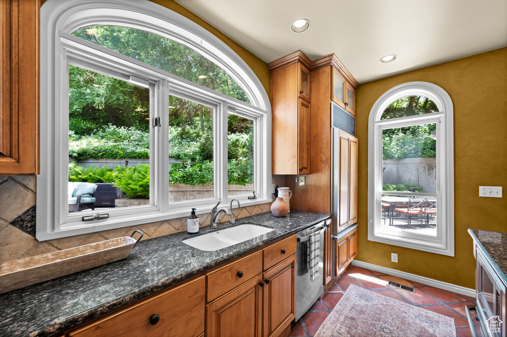 Kitchen with a sink, dishwasher, brown cabinets, tasteful backsplash, and recessed lighting