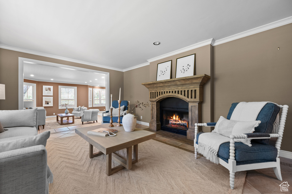 Living area featuring ornamental molding, recessed lighting, a fireplace with flush hearth, and baseboards