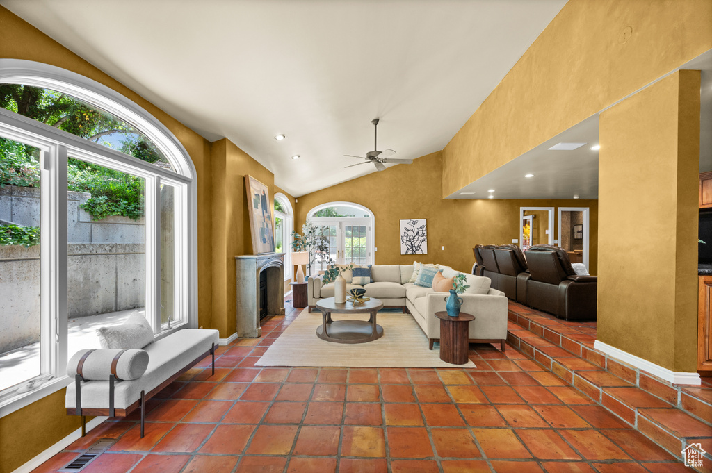 Living room with a fireplace, ceiling fan, recessed lighting, high vaulted ceiling, and baseboards