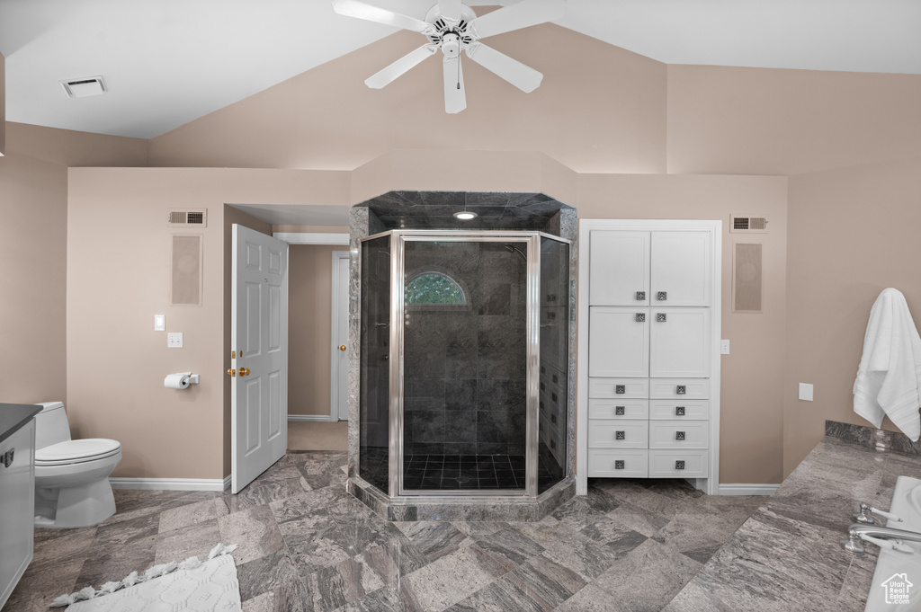 Bathroom with vaulted ceiling, a shower stall, ceiling fan, toilet, and baseboards