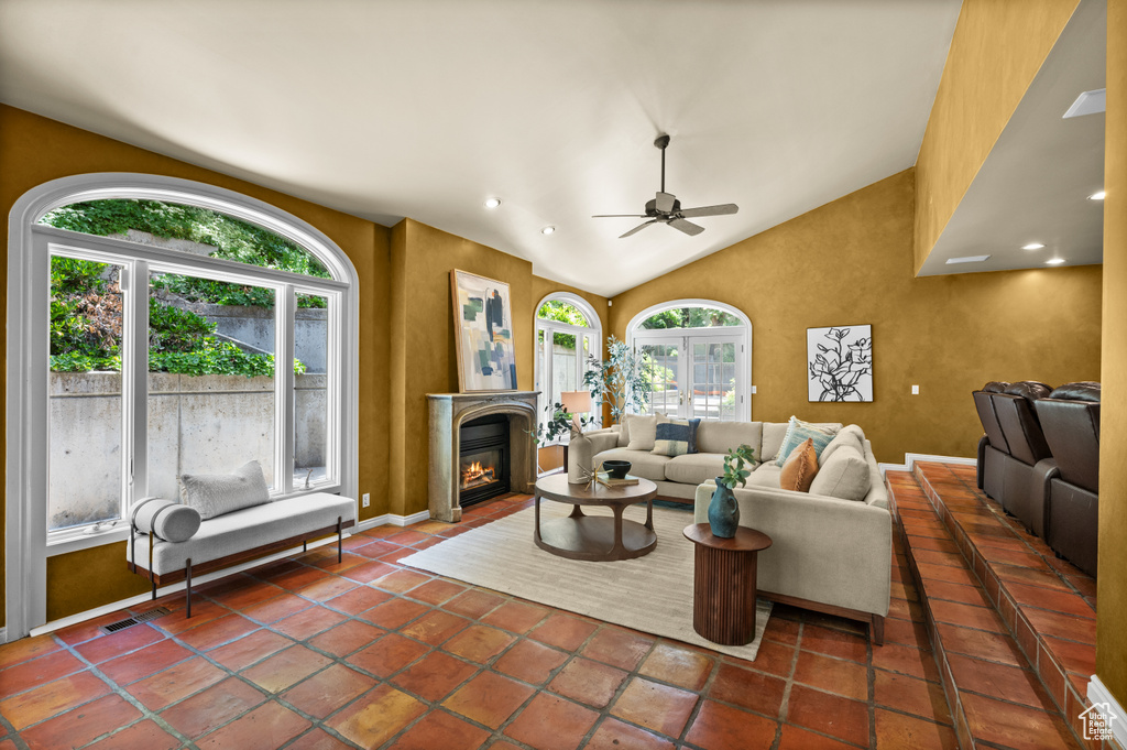 Living room featuring healthy amount of natural light, a ceiling fan, a glass covered fireplace, vaulted ceiling, and recessed lighting