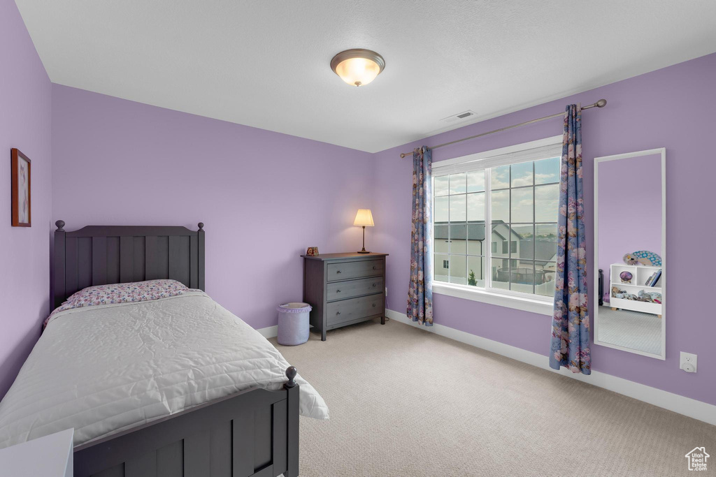 Bedroom with light colored carpet and baseboards