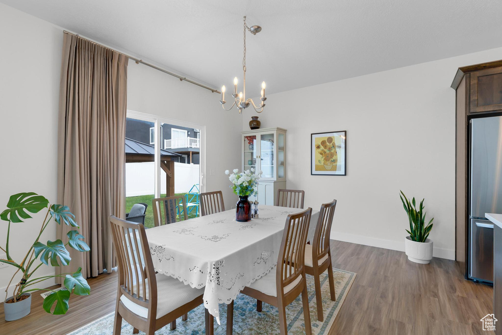 Dining room featuring a chandelier, wood finished floors, and baseboards
