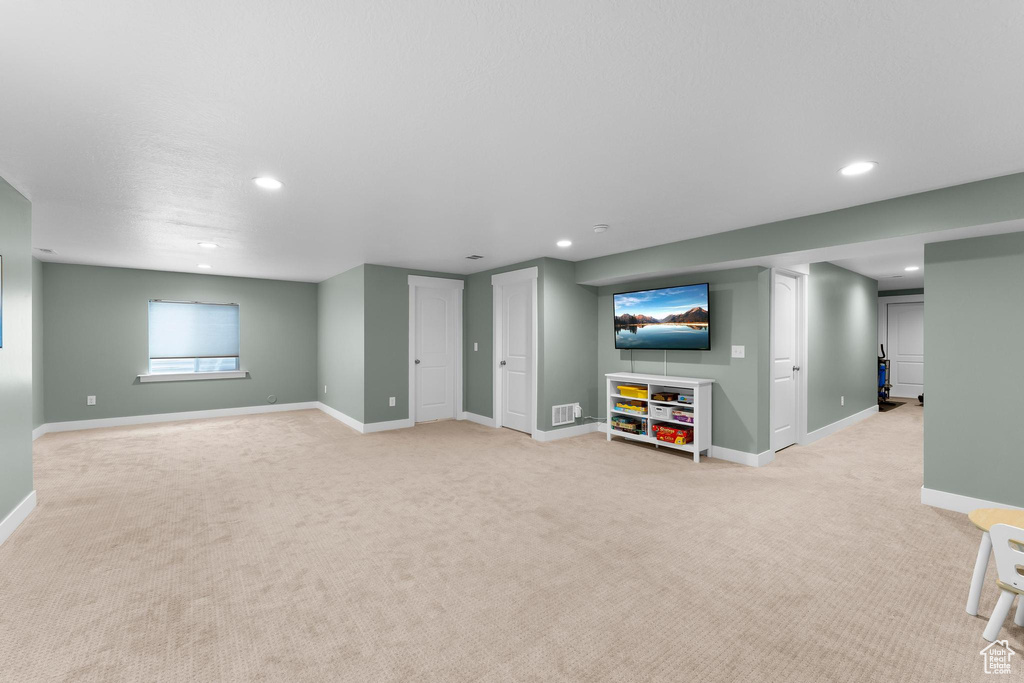 Below grade area with light colored carpet, recessed lighting, and baseboards