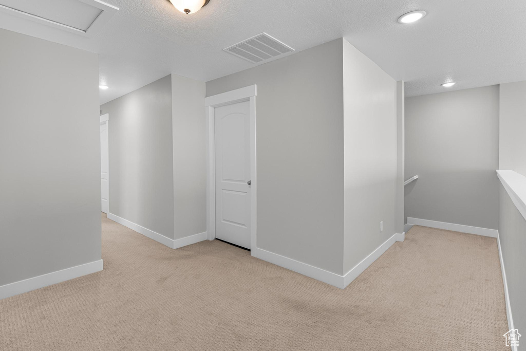 Hallway with carpet, an upstairs landing, baseboards, recessed lighting, and a textured ceiling
