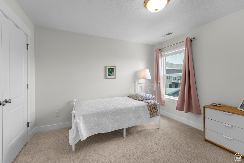 Bedroom with light colored carpet and baseboards