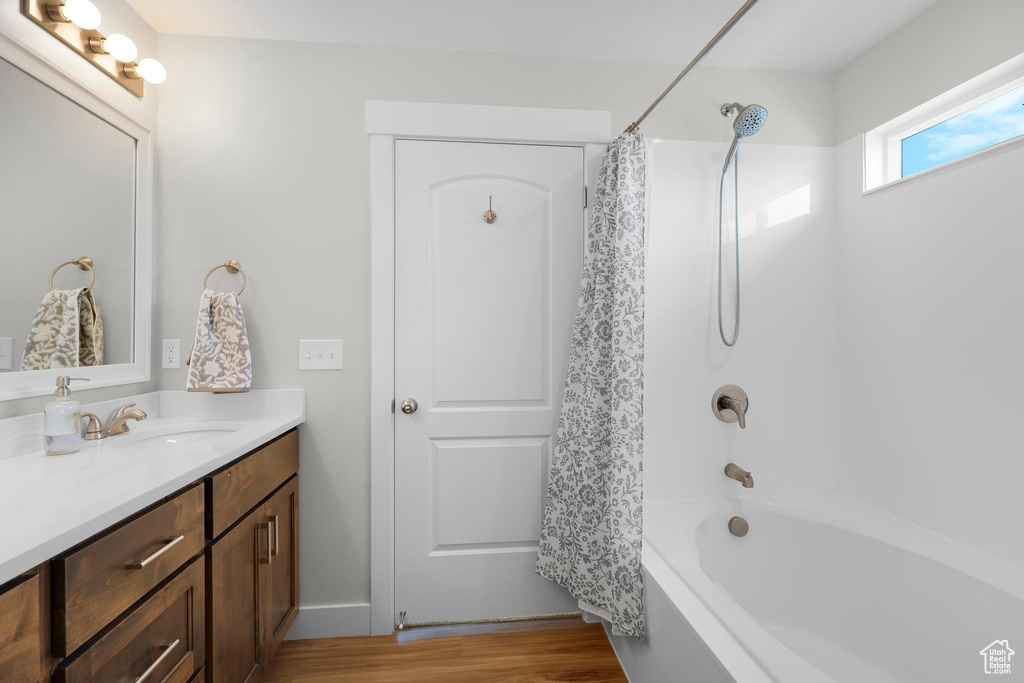 Full bathroom with vanity, shower / bath combination with curtain, and wood finished floors