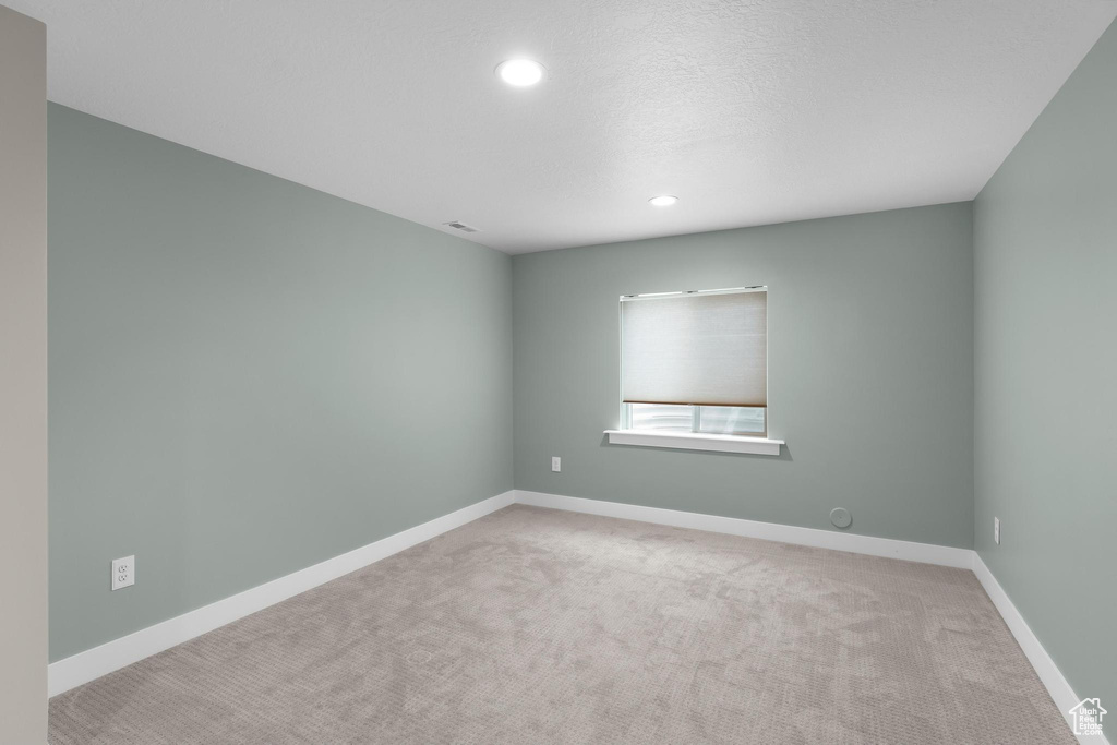 Empty room with carpet floors, recessed lighting, and baseboards