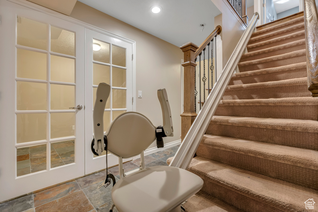 Stairway with stone finish flooring and recessed lighting
