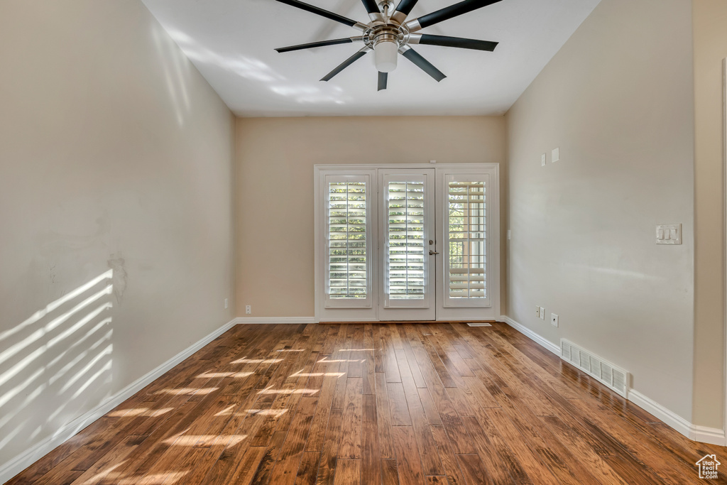 Empty room featuring a ceiling fan, wood finished floors, and baseboards