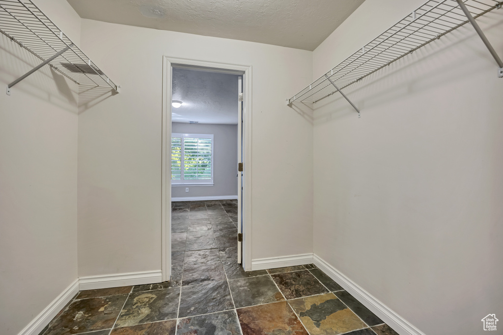 Spacious closet with stone tile flooring