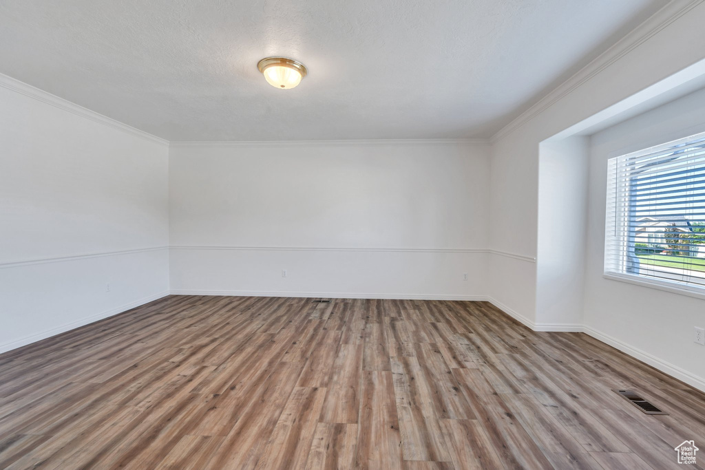 Empty room with wood finished floors and crown molding