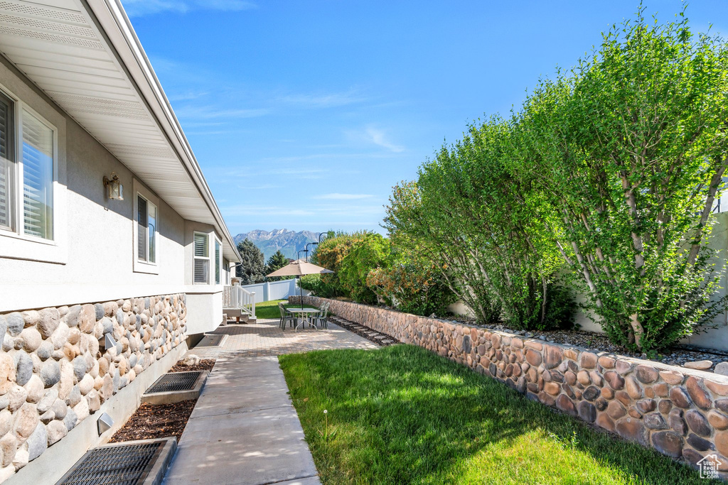 Fenced backyard featuring a patio area and a mountain view