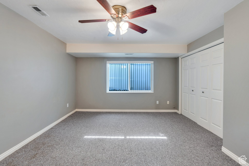 Unfurnished bedroom featuring carpet, a closet, and a ceiling fan