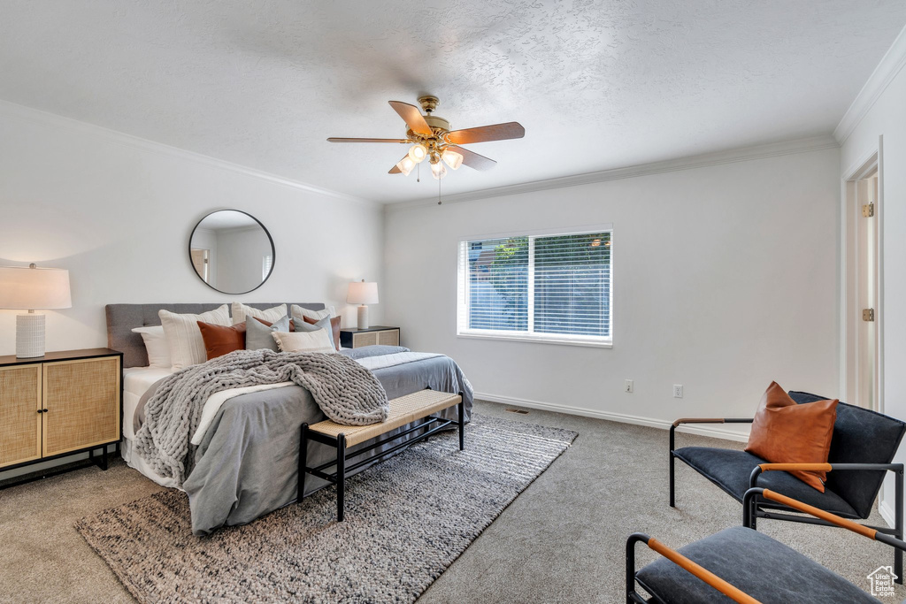 Bedroom with ornamental molding, carpet flooring, and ceiling fan
