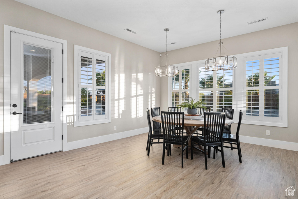Dining space featuring a chandelier, light wood-style floors, and plenty of natural light