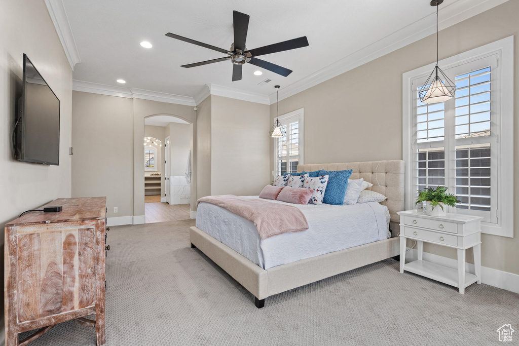 Carpeted bedroom with arched walkways, crown molding, recessed lighting, and ceiling fan