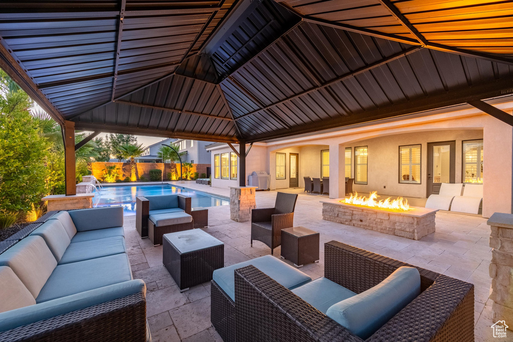 View of patio / terrace featuring an outdoor living space with a fire pit and a gazebo