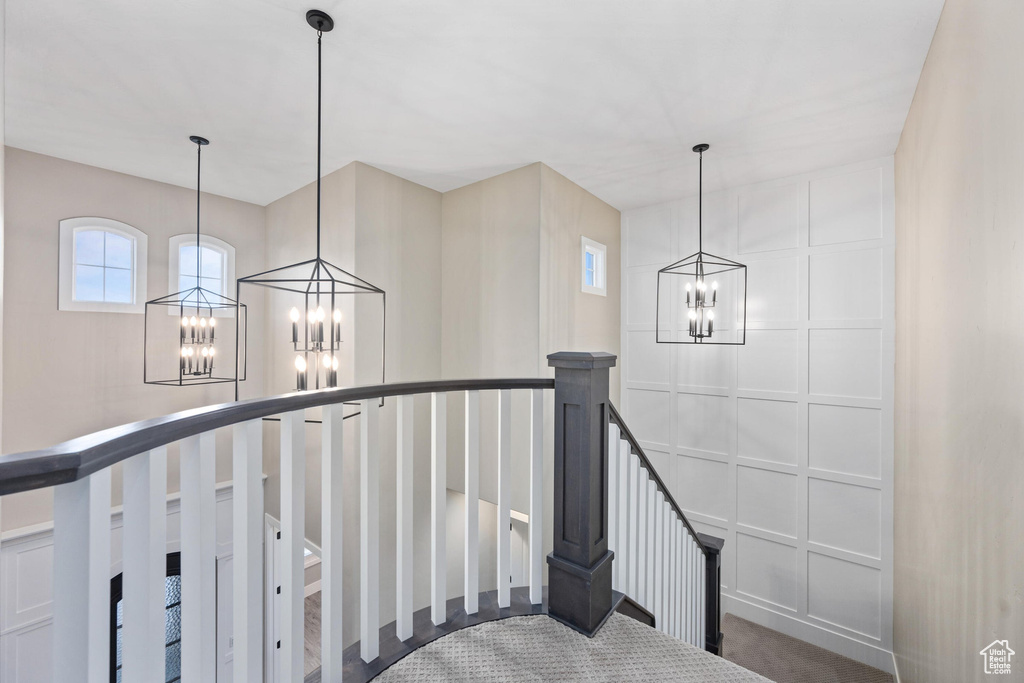 Stairway with a chandelier and carpet floors