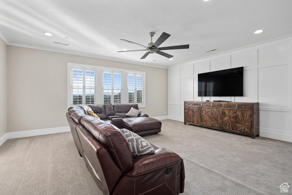 Living room with light colored carpet, crown molding, a ceiling fan, and recessed lighting