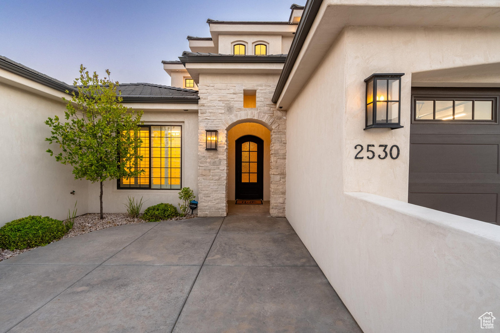Entrance to property featuring stucco siding and stone siding
