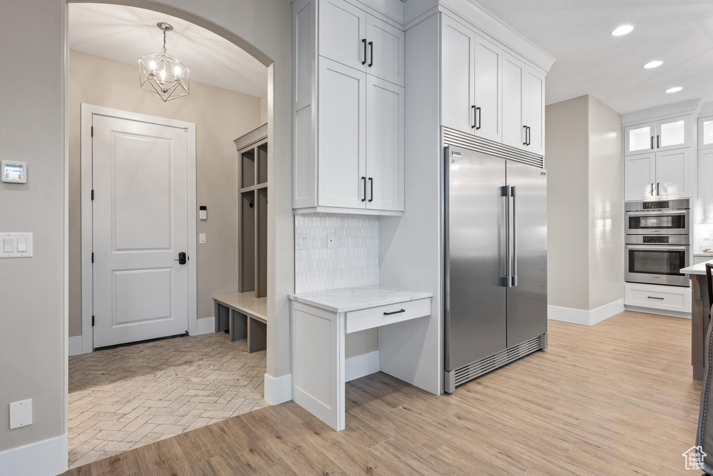 Mudroom featuring arched walkways, recessed lighting, a chandelier, and light wood-style flooring
