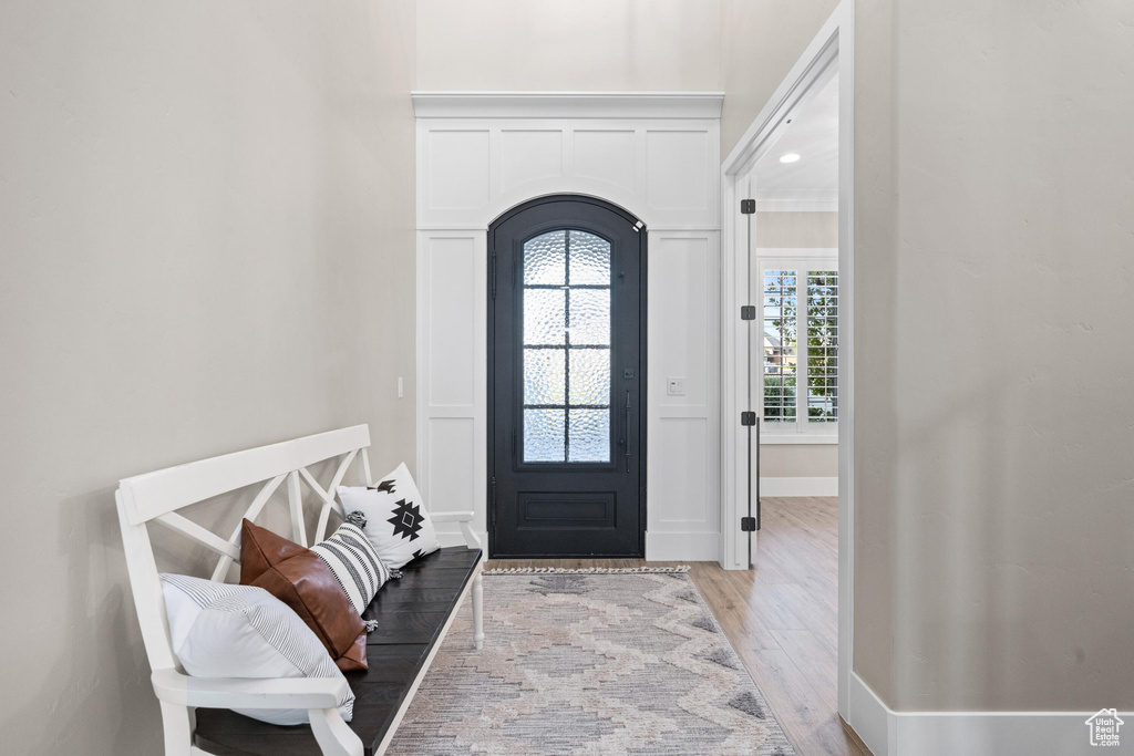 Entryway featuring arched walkways and light wood-type flooring