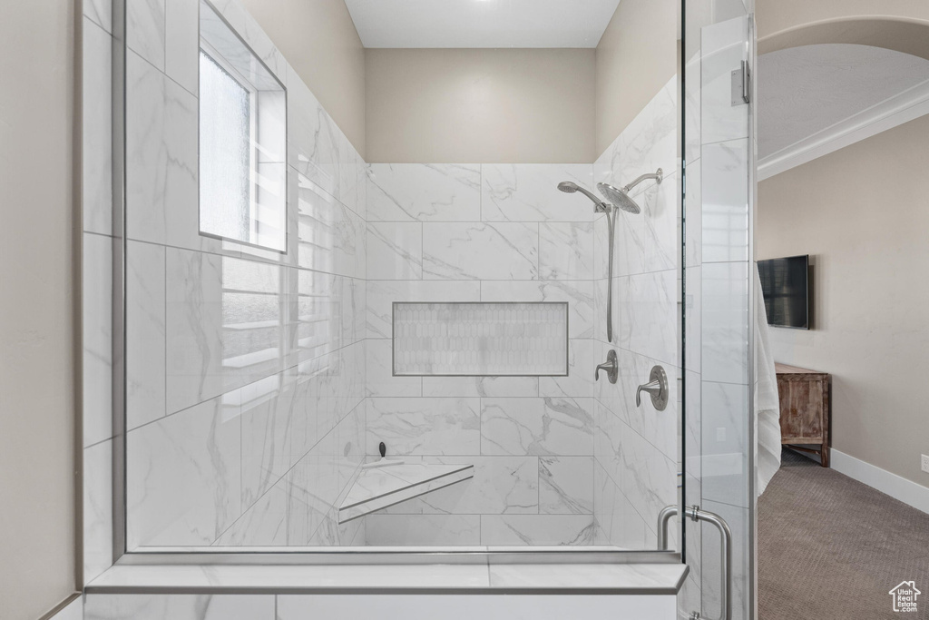 Bathroom with a shower stall and baseboards