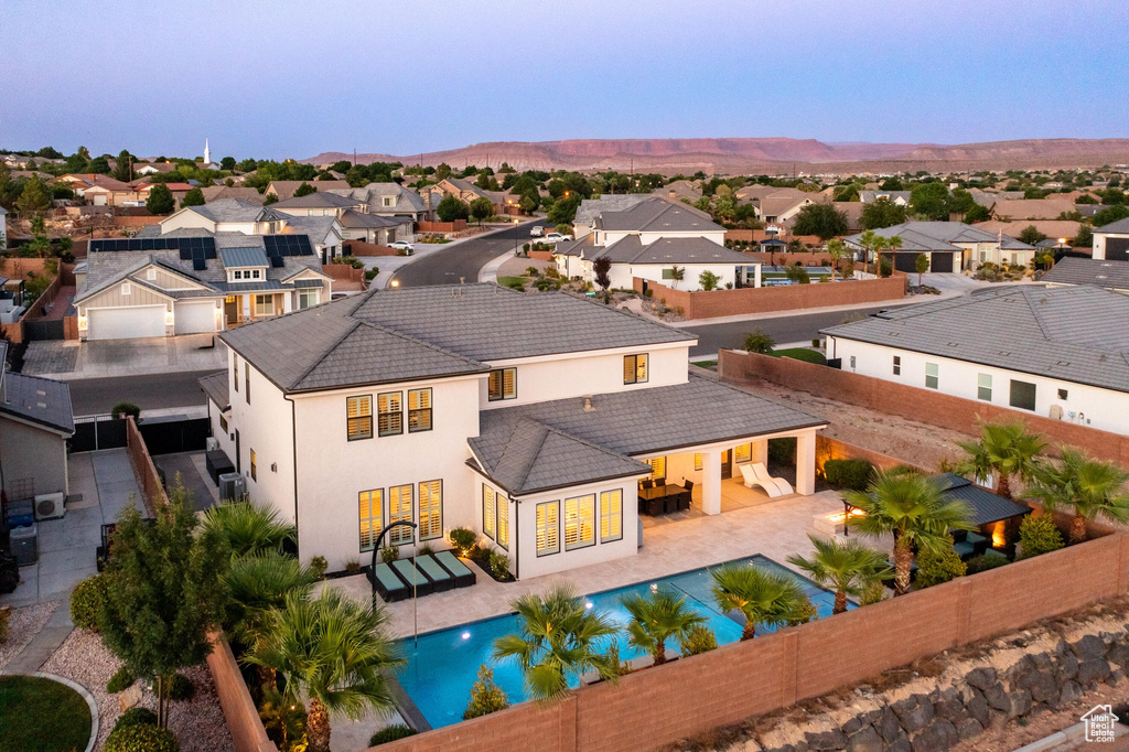 Back of property with a fenced backyard, a residential view, stucco siding, a tile roof, and a mountain view